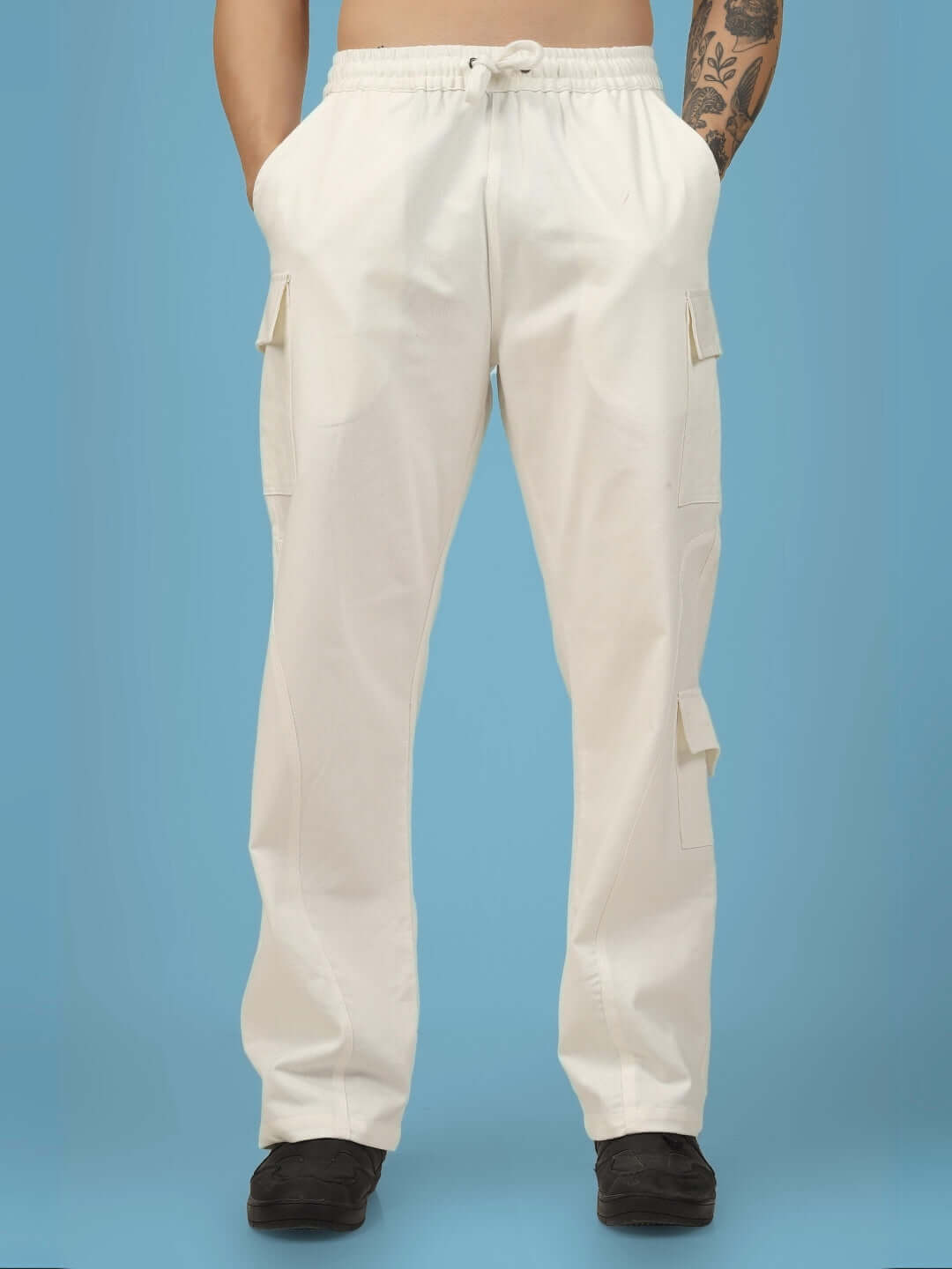 White cotton twill cargo pants with six pockets, model wearing in front view on a blue background.