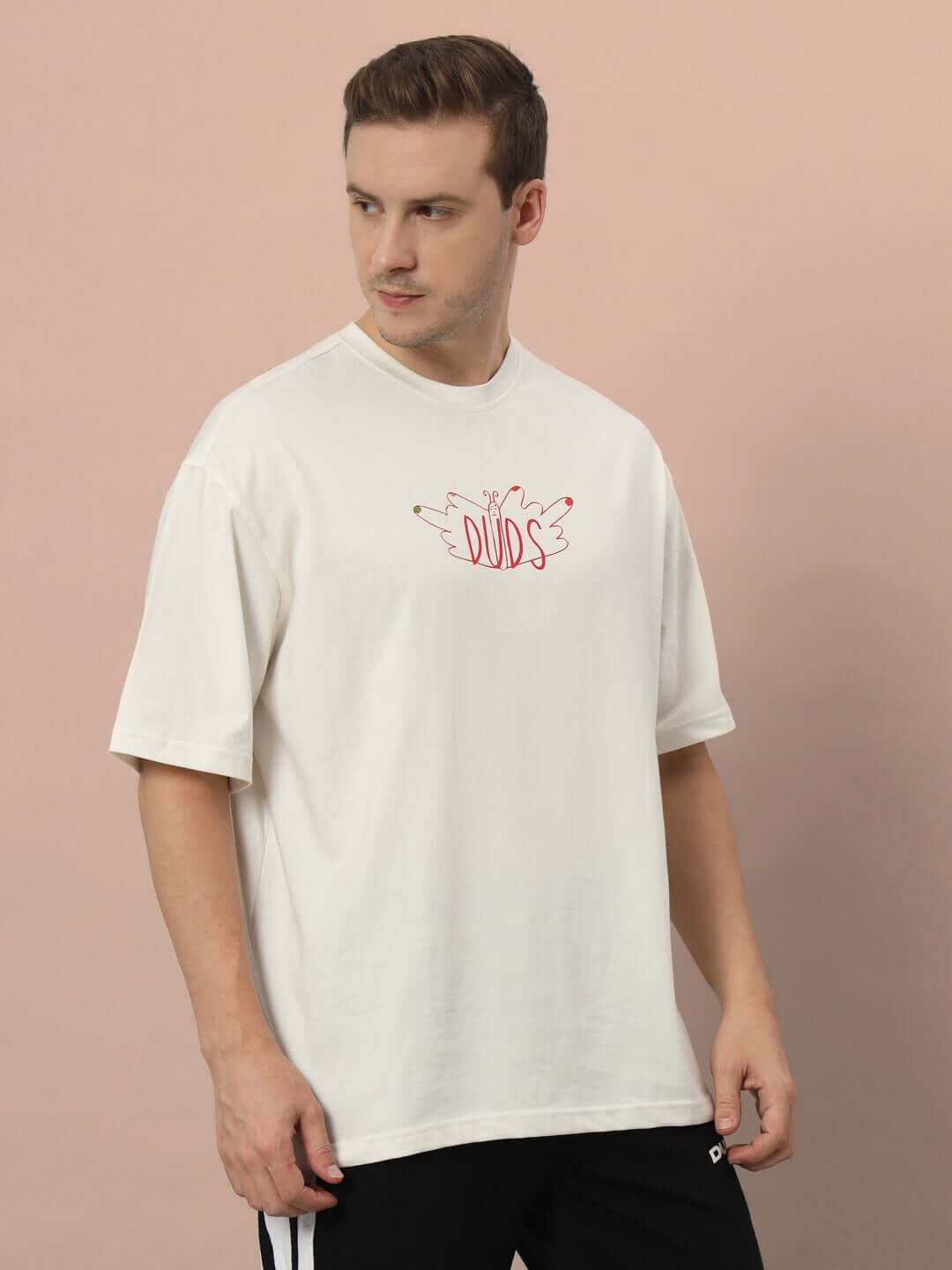 Male model wearing ONE STEP AT A TIME OVER-SIZED T-SHIRT OFF WHITE, made of 100% cotton, showcasing premium heavy gauge fabric.
