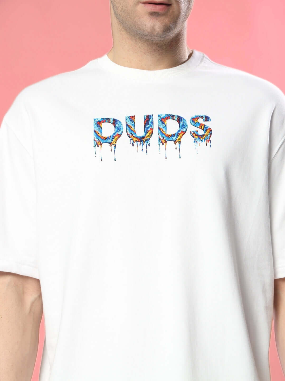 Person wearing MELTING EARTH OVER-SIZED T-SHIRT WHITE with bold graphic on pink background.