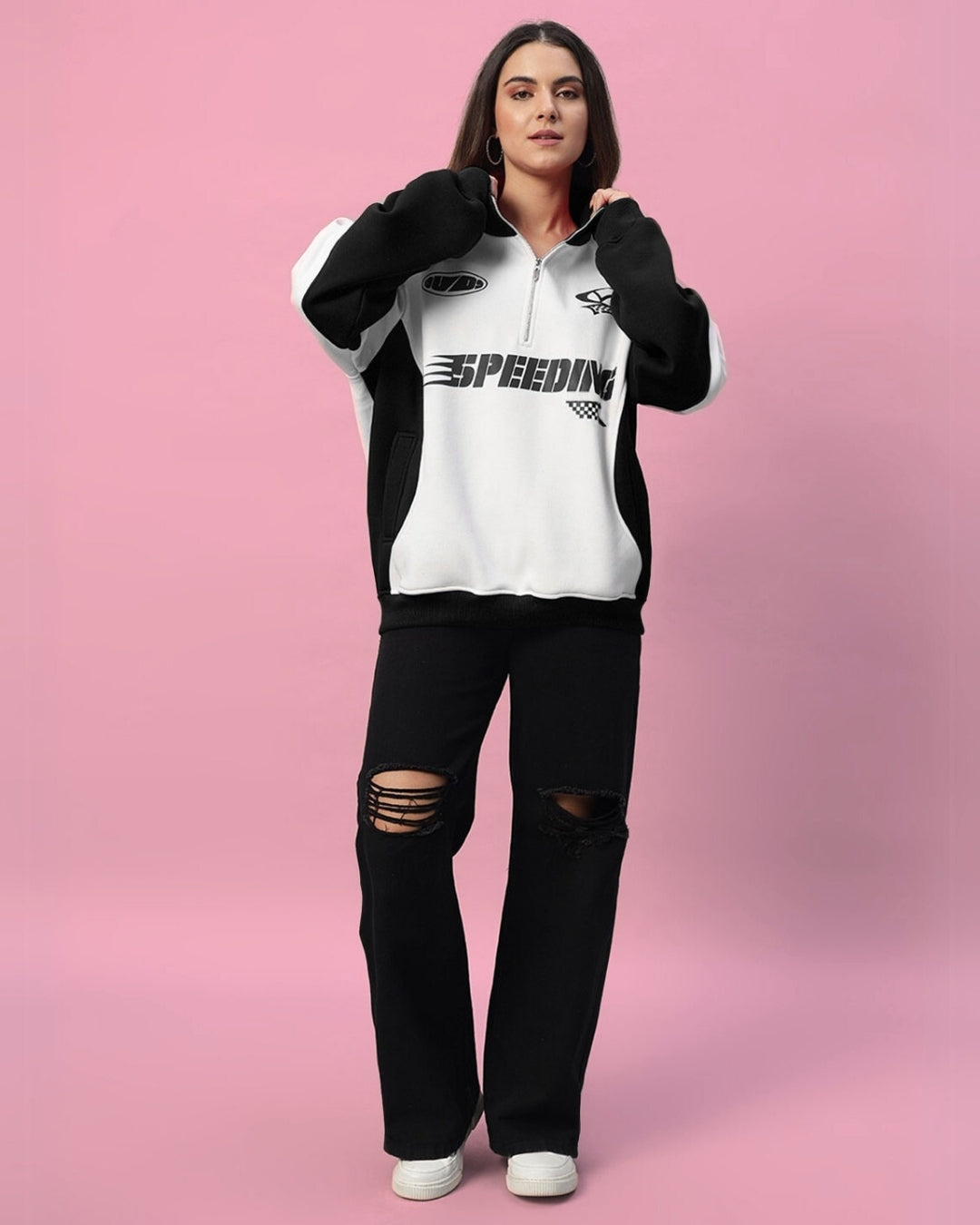 Woman wearing the Women's Speeding Colorblock Jacket in black with a bold pattern, styled with distressed jeans, on a pink background.