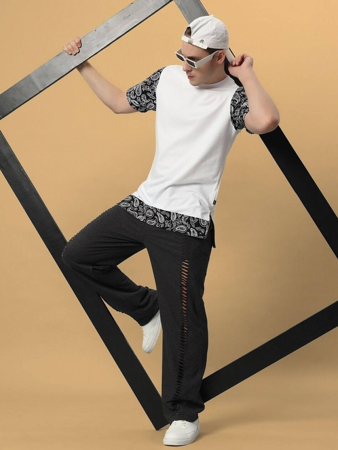 Man wearing BEASLEY Over-Sized T-Shirt in white with black patterned sleeves, styled casually with sunglasses and a cap.
