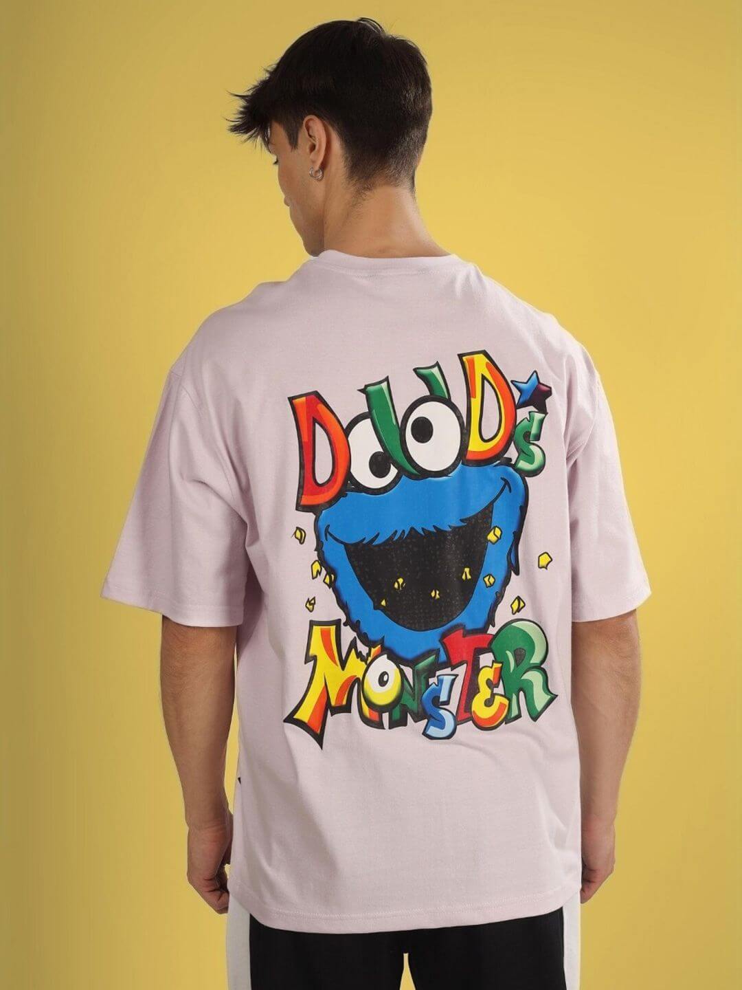 Back view of DUDS MONSTER OVER-SIZED T-SHIRT PALE PINK with colorful monster graphic on yellow background.