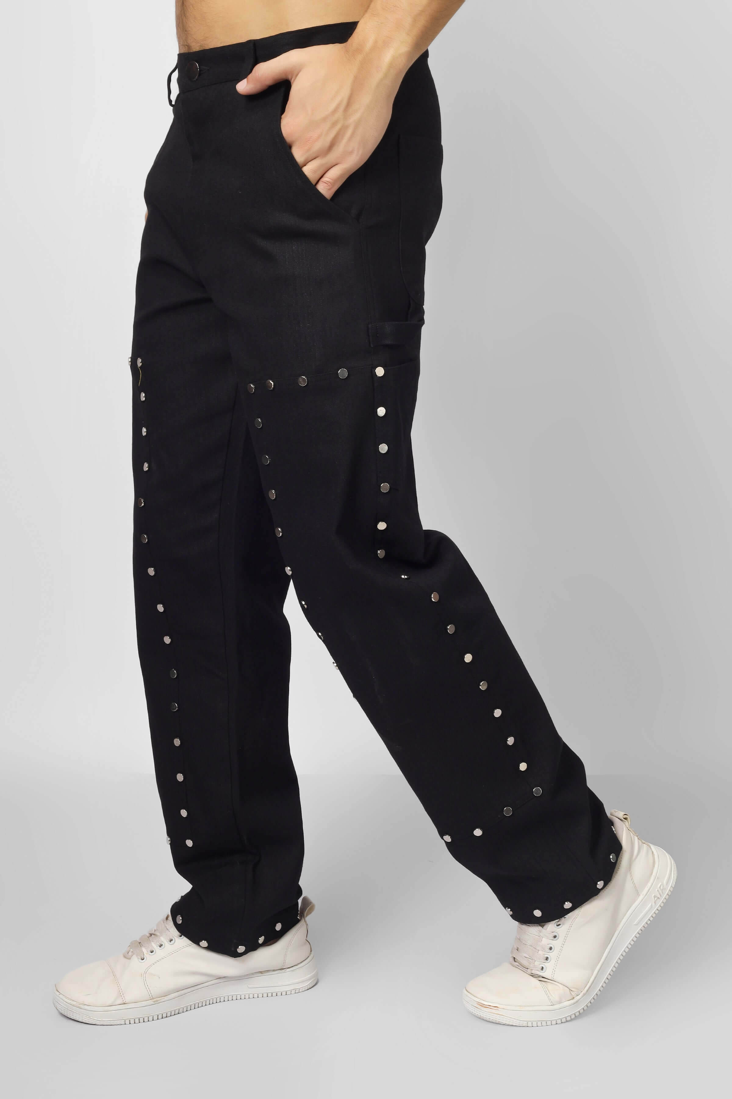 7 pocket multi metal stud button pants in black shown with white sneakers, featuring durable cotton twill fabric and contemporary design.