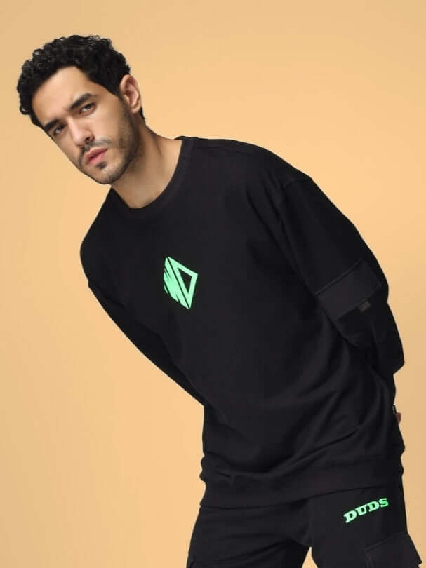 Model wearing WD oversized cotton terry sweatshirt in black with neon logo on a beige background