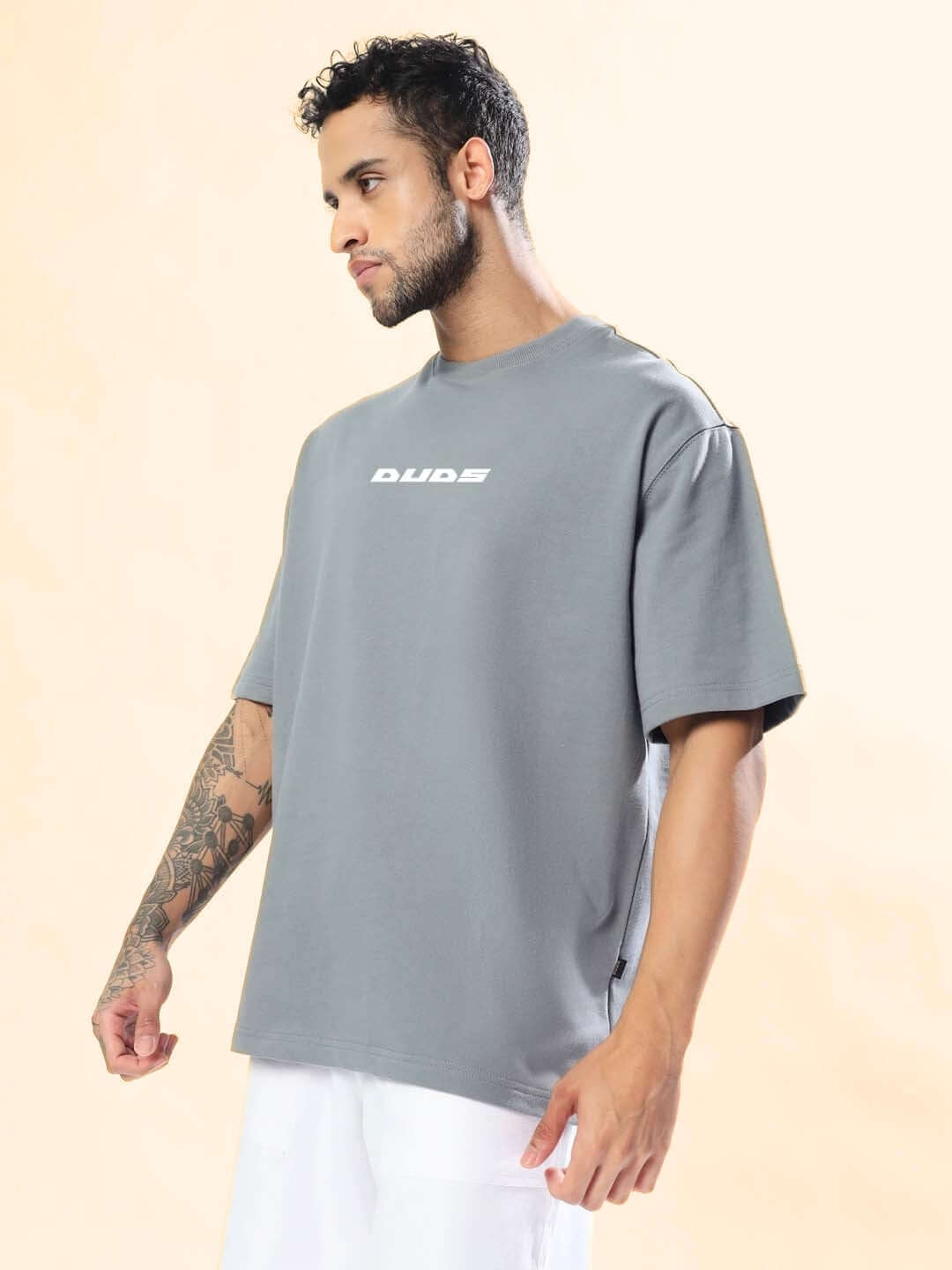 Man wearing ONLY HOPE REMAINS OVER-SIZED T-SHIRT GREY with bold graphic print showcasing streetwear style in breathable cotton fabric.