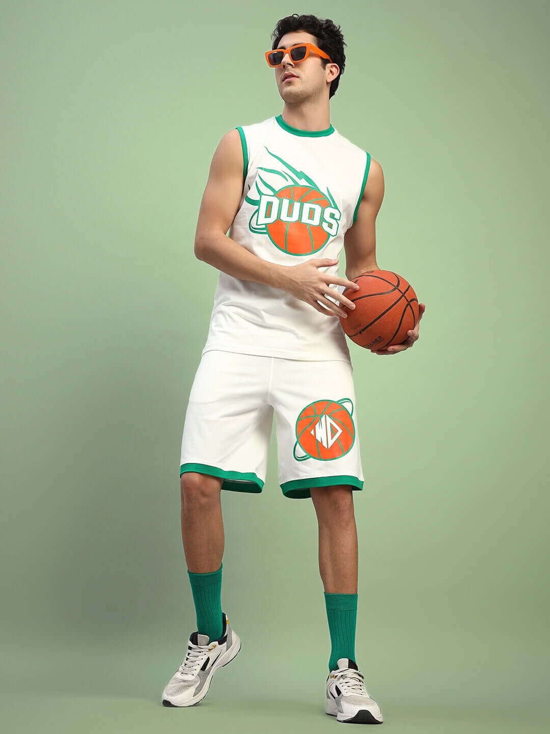 Man wearing DRIBBLE SUMMER SHORTS in off-white, holding a basketball, sporting a casual athletic outfit by DUDS.