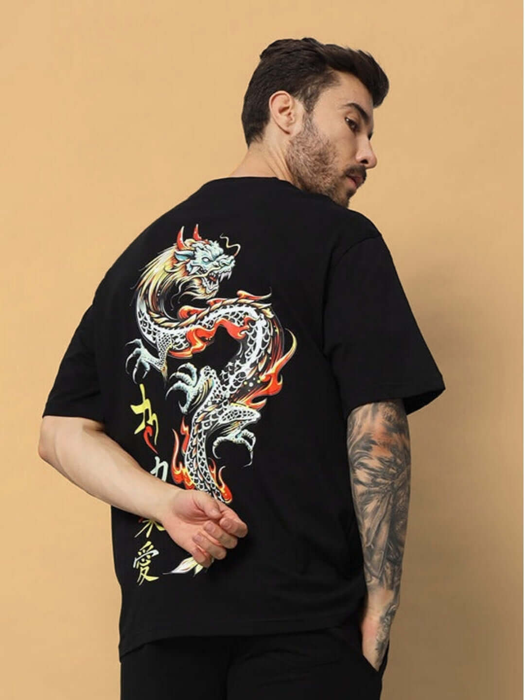 Man wearing KAKAAI OVER-SIZED T-SHIRT BLACK with dragon print on back