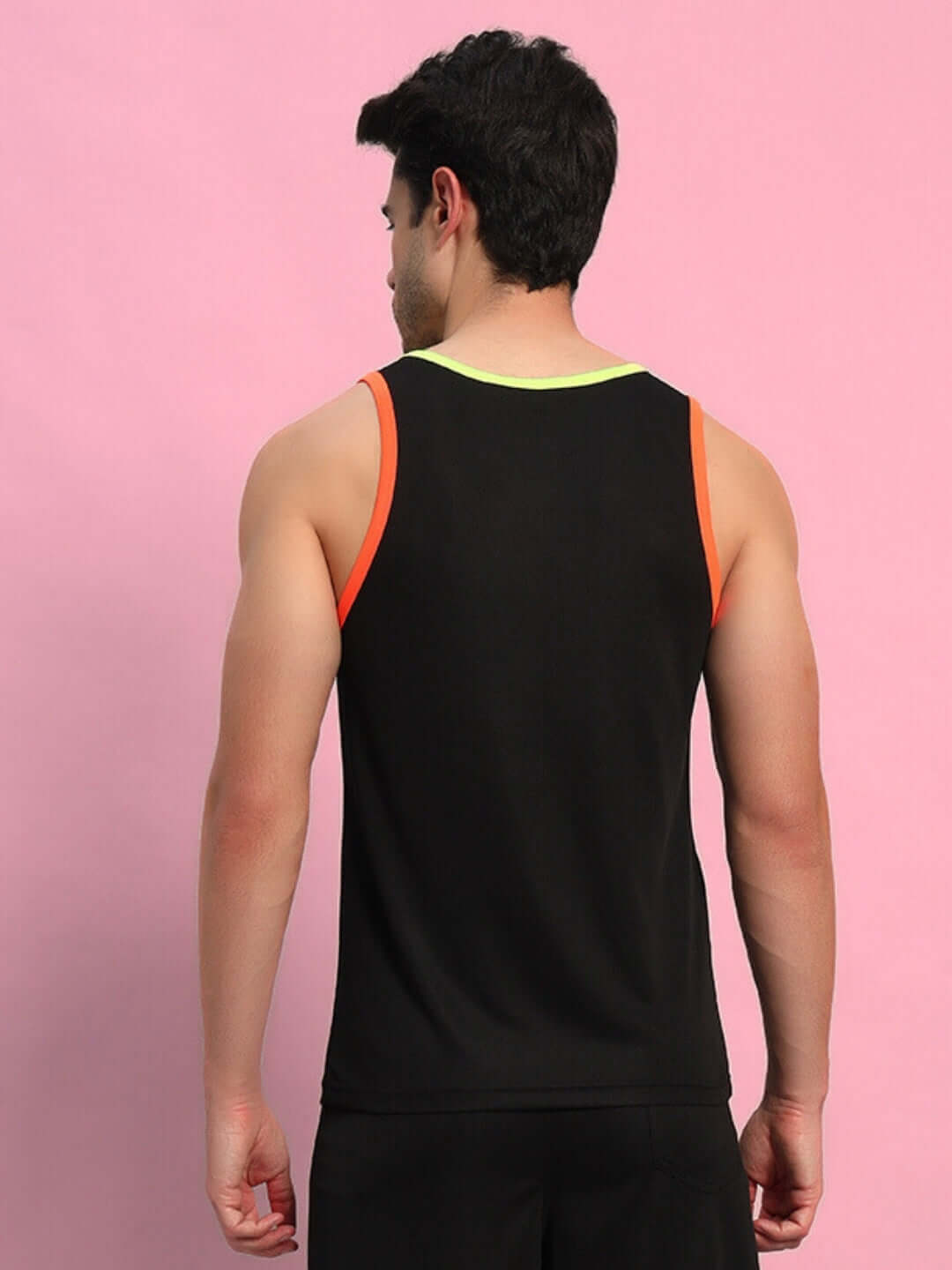 Back view of a person wearing a black gym t-shirt against a pink background.