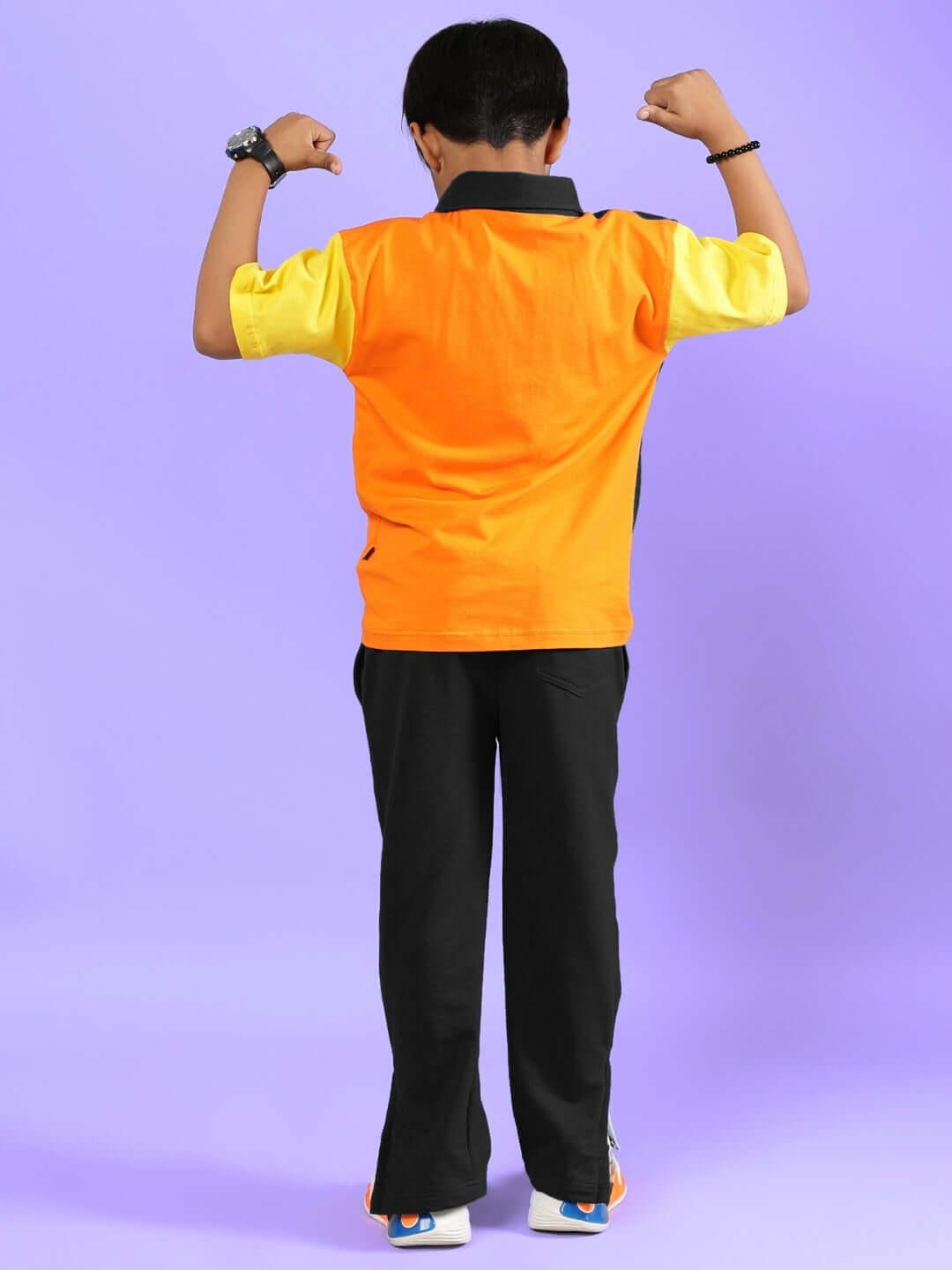 Child wearing APEX multi-black co-ord set, back view, showcasing vibrant design and stylish fit on purple background.