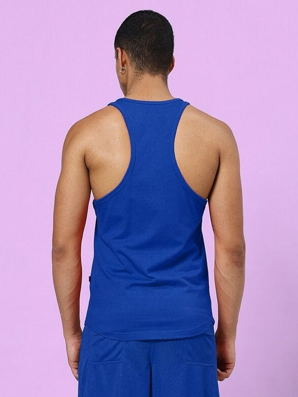 Man wearing TAKE IT EASY GYM VEST T-SHIRT BLUE, back view on pink background.