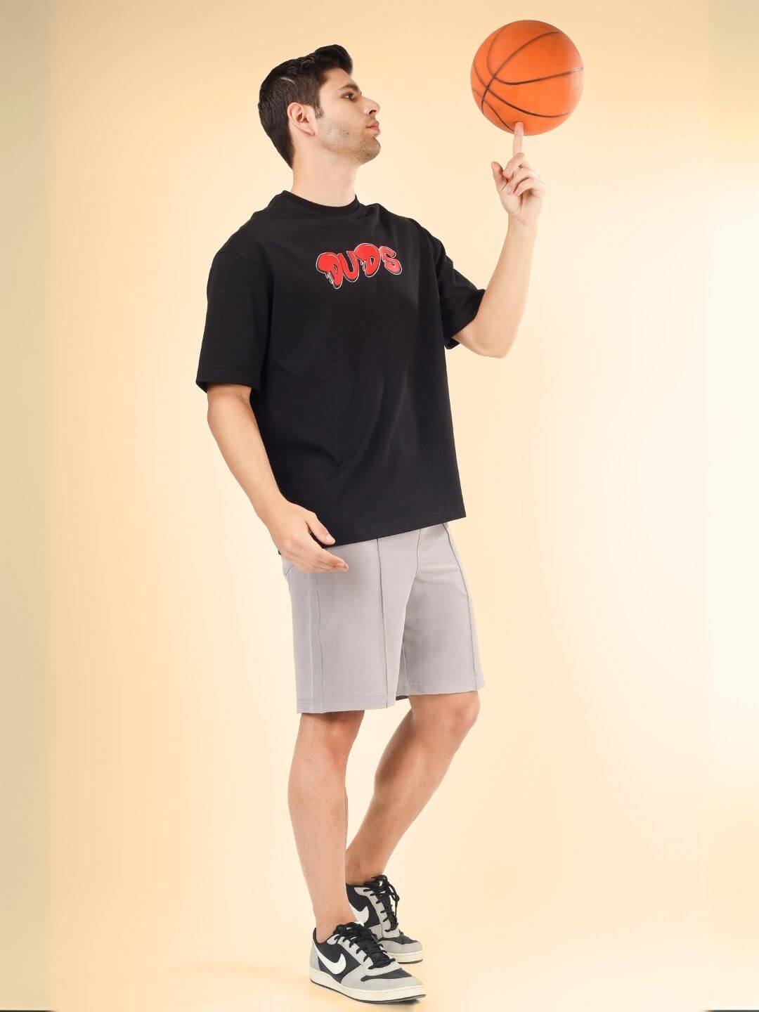 Man wearing DRIP 2 HARD OVER-SIZED T-SHIRT BLACK playing with basketball