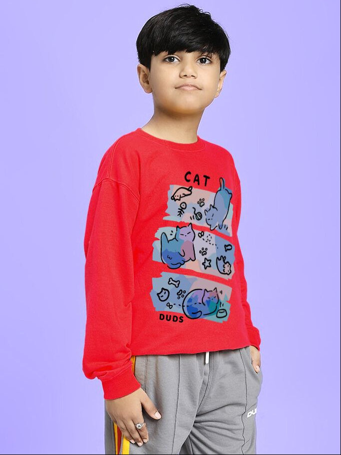 Boy wearing CAT LOVERS SWEATSHIRT FOR BOYS AND GIRLS RED with playful cat graphic on blue background.