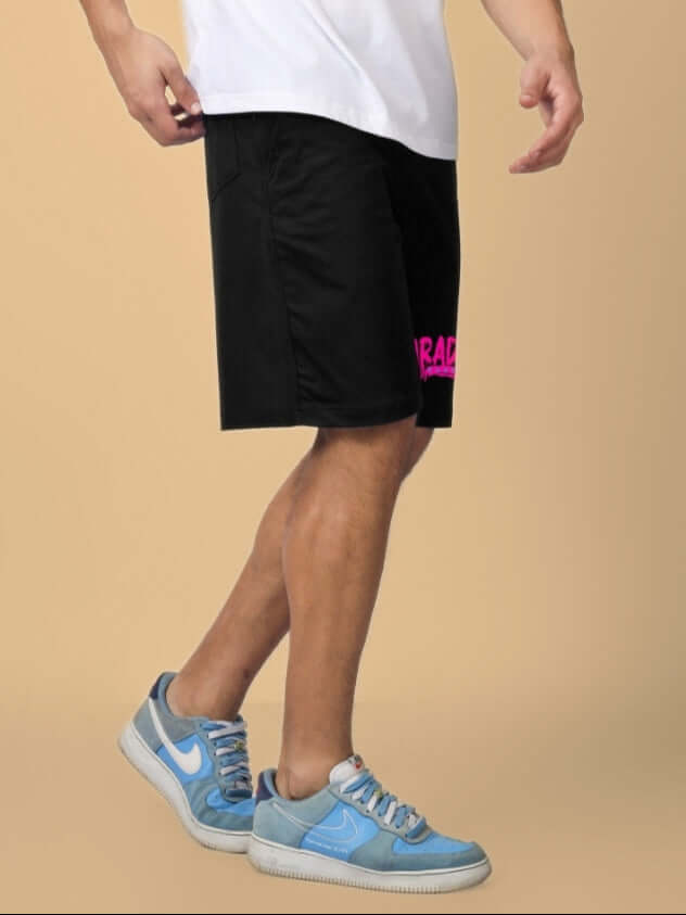 Man wearing FULNESS PARADISE Summer Shorts in black, standing with casual blue sneakers, highlighting comfort and style.