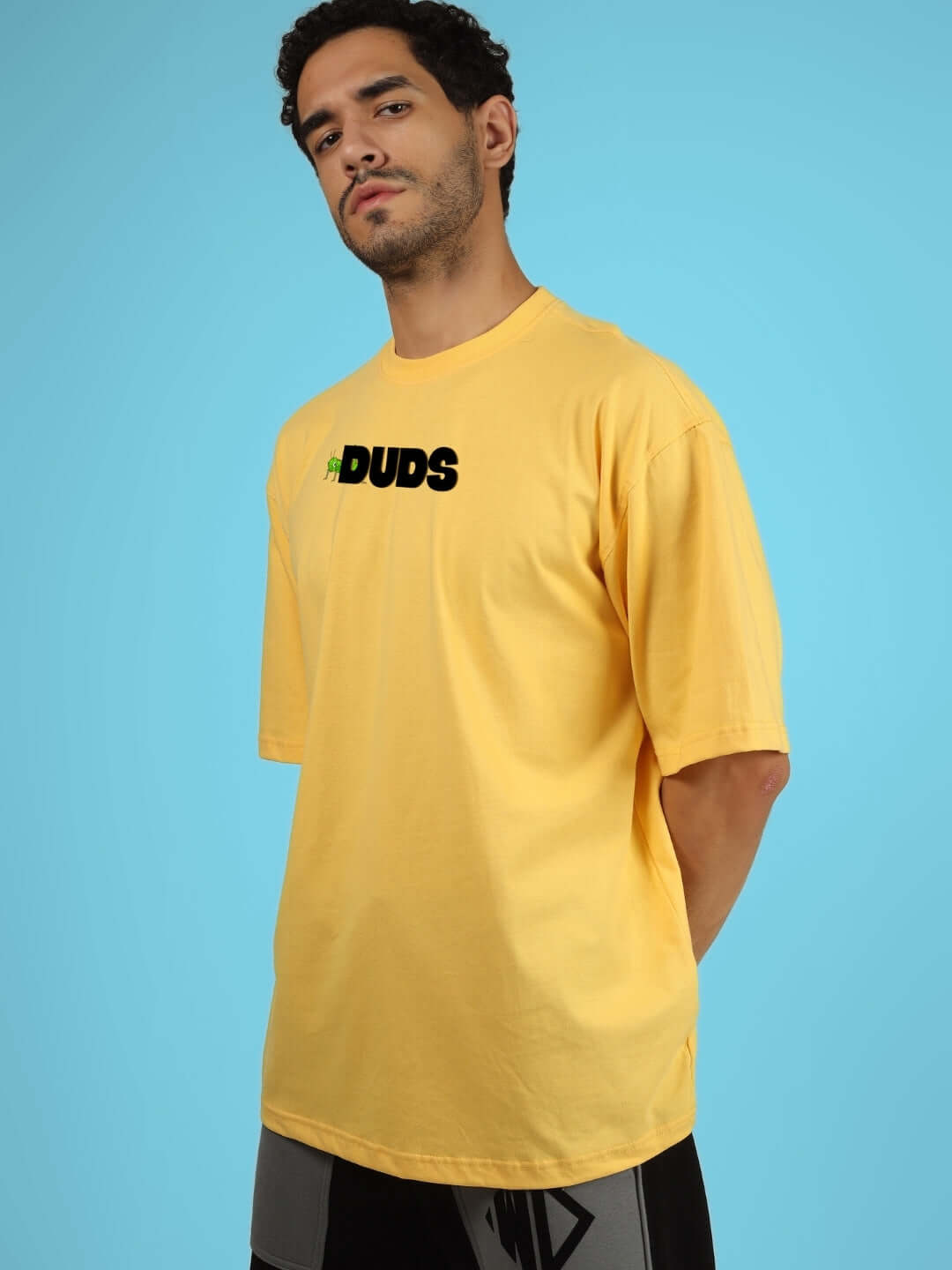 Model wearing LOCUST OVER-SIZED T-SHIRT YELLOW by DUDS, showcasing casual style with custom fit options.