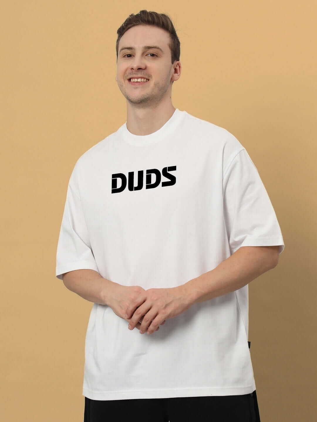 LIVING THE LIFE OVER-SIZED T-SHIRT WHITE, premium heavy gauge fabric, 100% cotton, wearing casually in front of beige background.