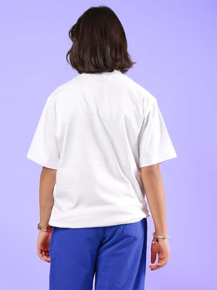 Back view of a child wearing a white Happy Vibes T-shirt with blue pants, showcasing casual style for boys and girls.