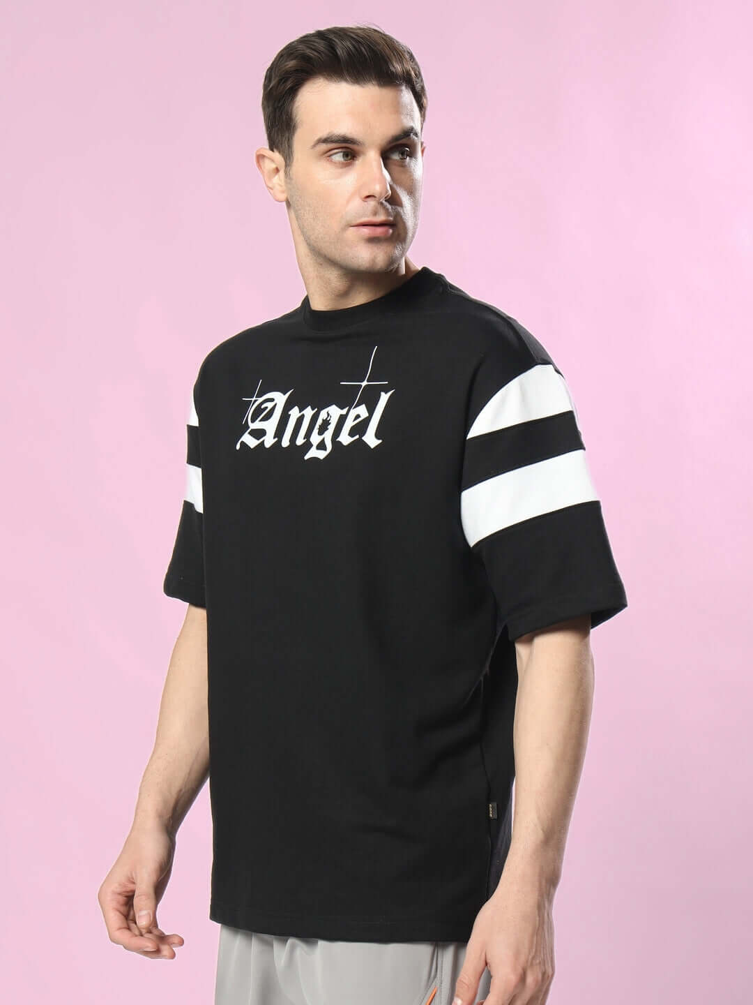 DIVINE SPIRIT OVERSIZED T-SHIRT BLACK on model with angel text and striped sleeves.
