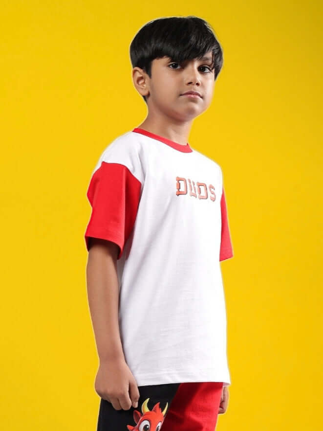 Child wearing DUDS Cassie T-Shirt in white-red, standing on a yellow background; perfect for boys and girls.