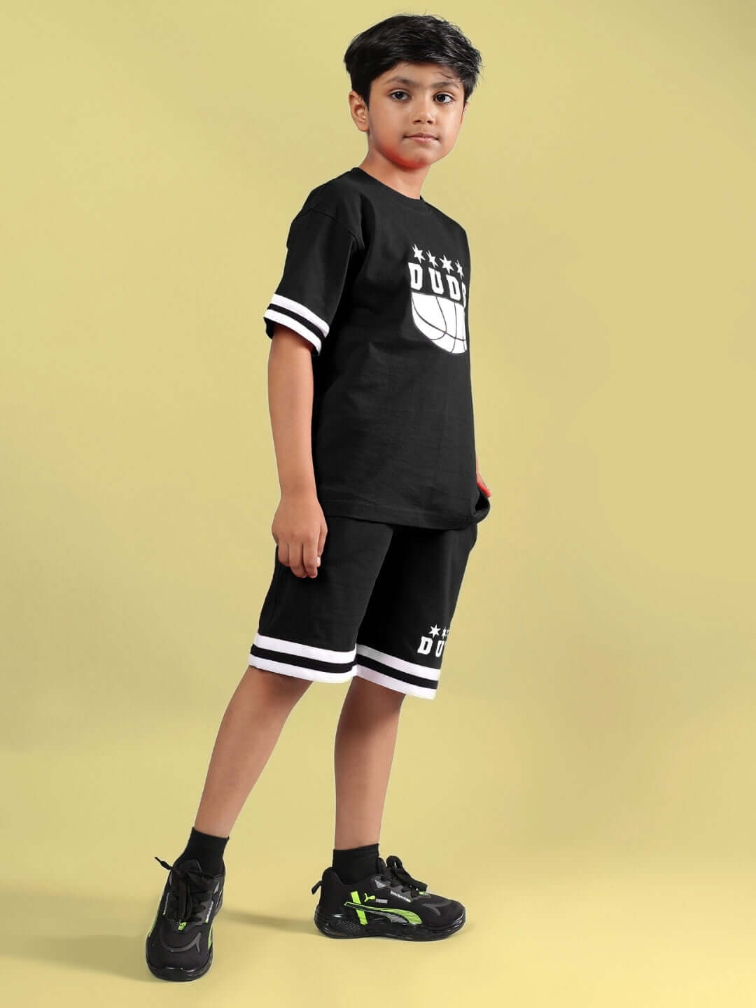 Young child wearing a black Diggin Co-ord set for boys and girls by DUDS, showcasing sporty styling and comfort, available for custom fit.