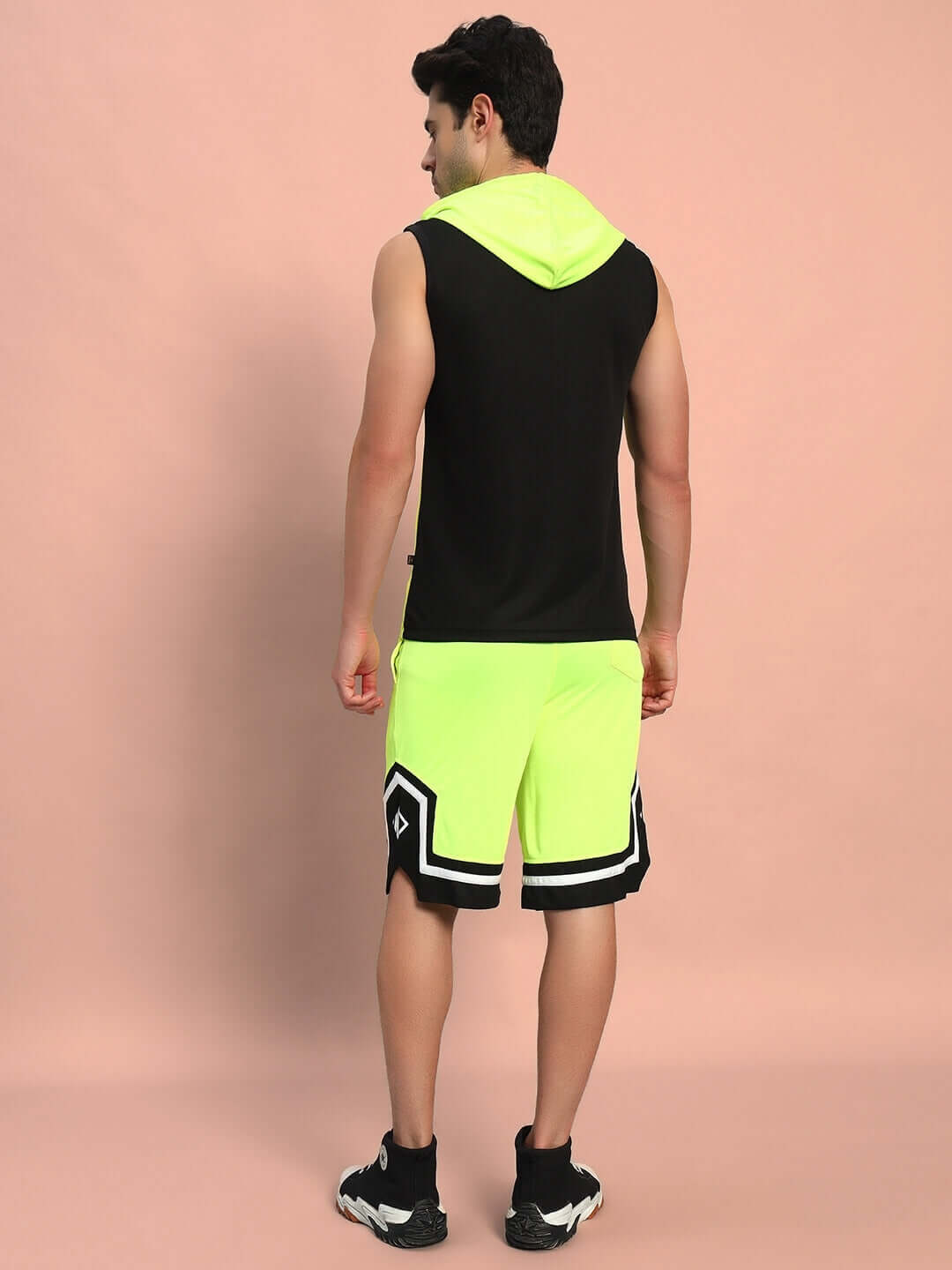Back view of a person wearing neon green Armado regular fit shorts with a black sleeveless hoodie, showcasing vibrant casual style.