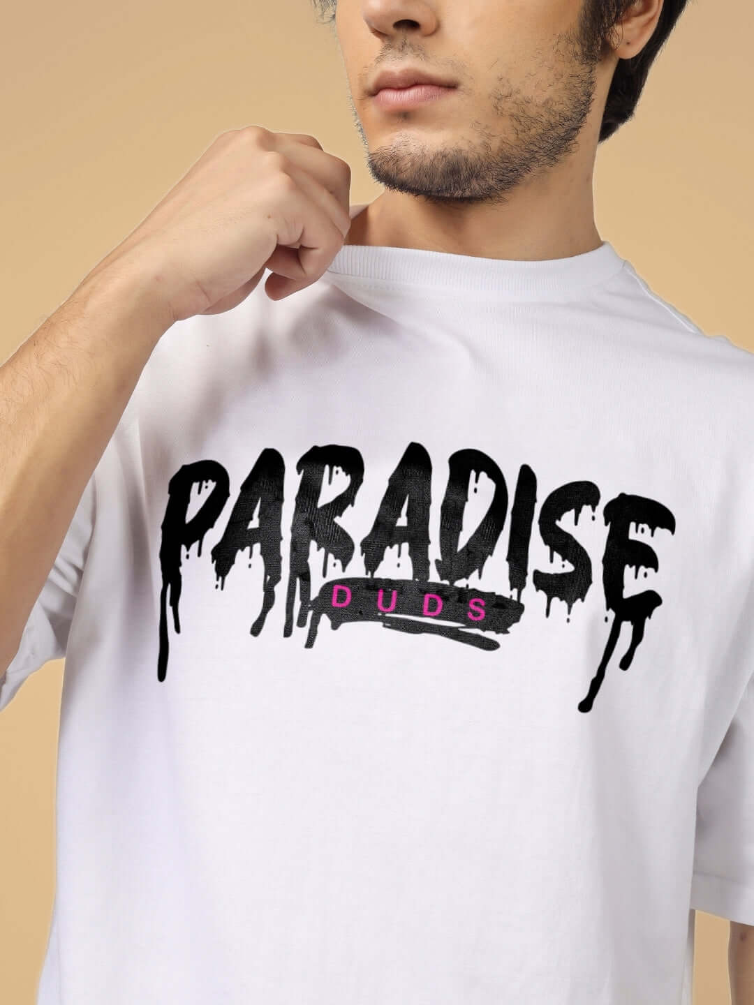 Man wearing white PARADISE DUDS t-shirt with black print, featuring a relaxed fit and soft fabric.