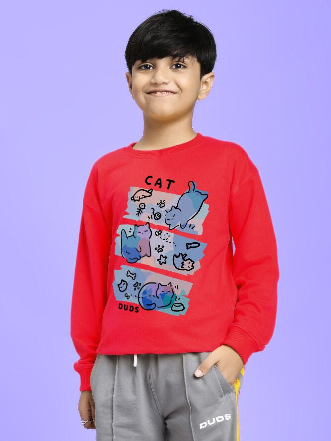 Child wearing CAT LOVERS SWEATSHIRT FOR BOYS AND GIRLS RED with cat graphic on a purple background, perfect for young trendsetters.
