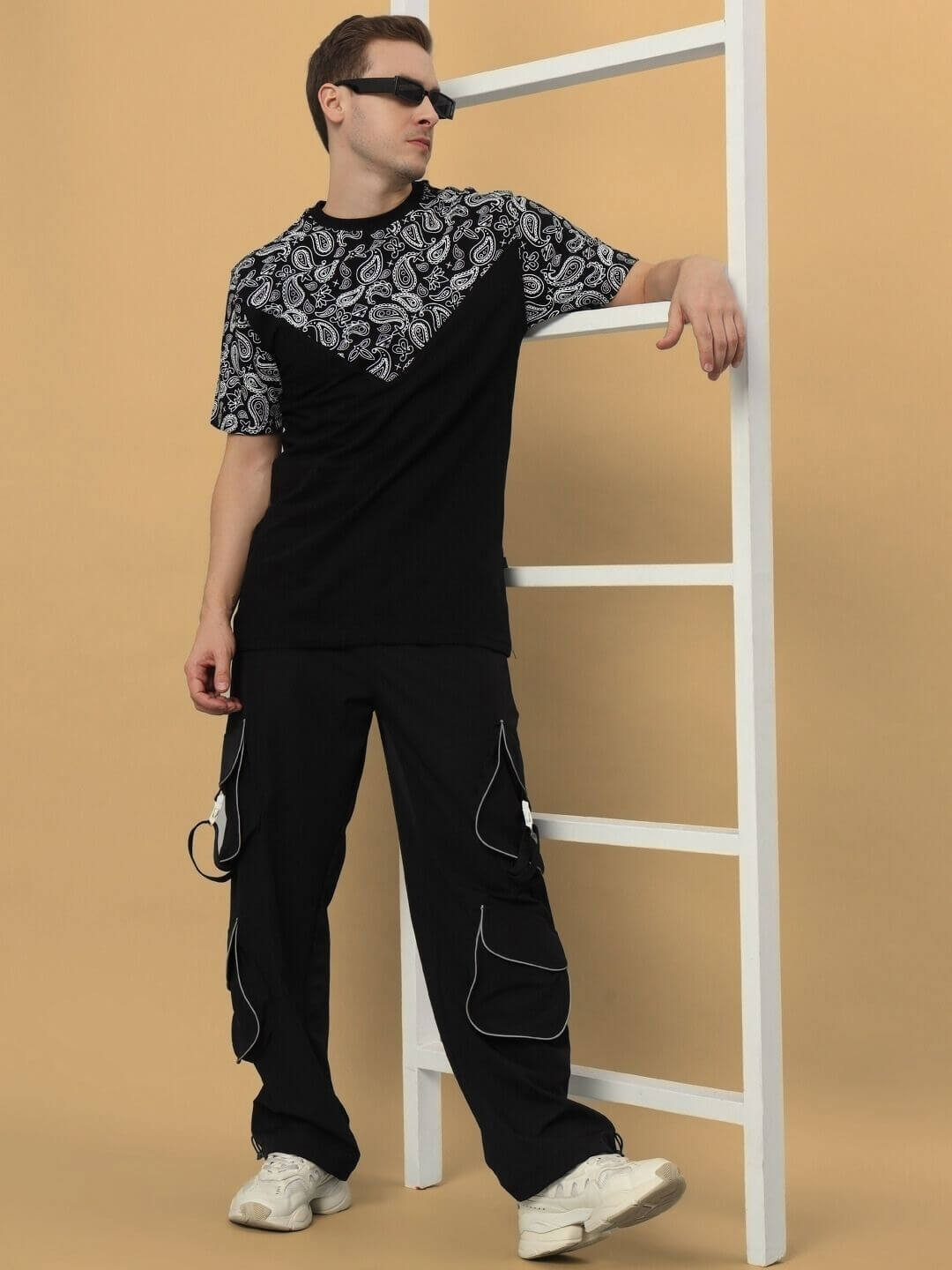 Man wearing the BALLADEER over-sized black T-shirt, featuring French terry premium cotton and elastane blend, paired with casual pants.