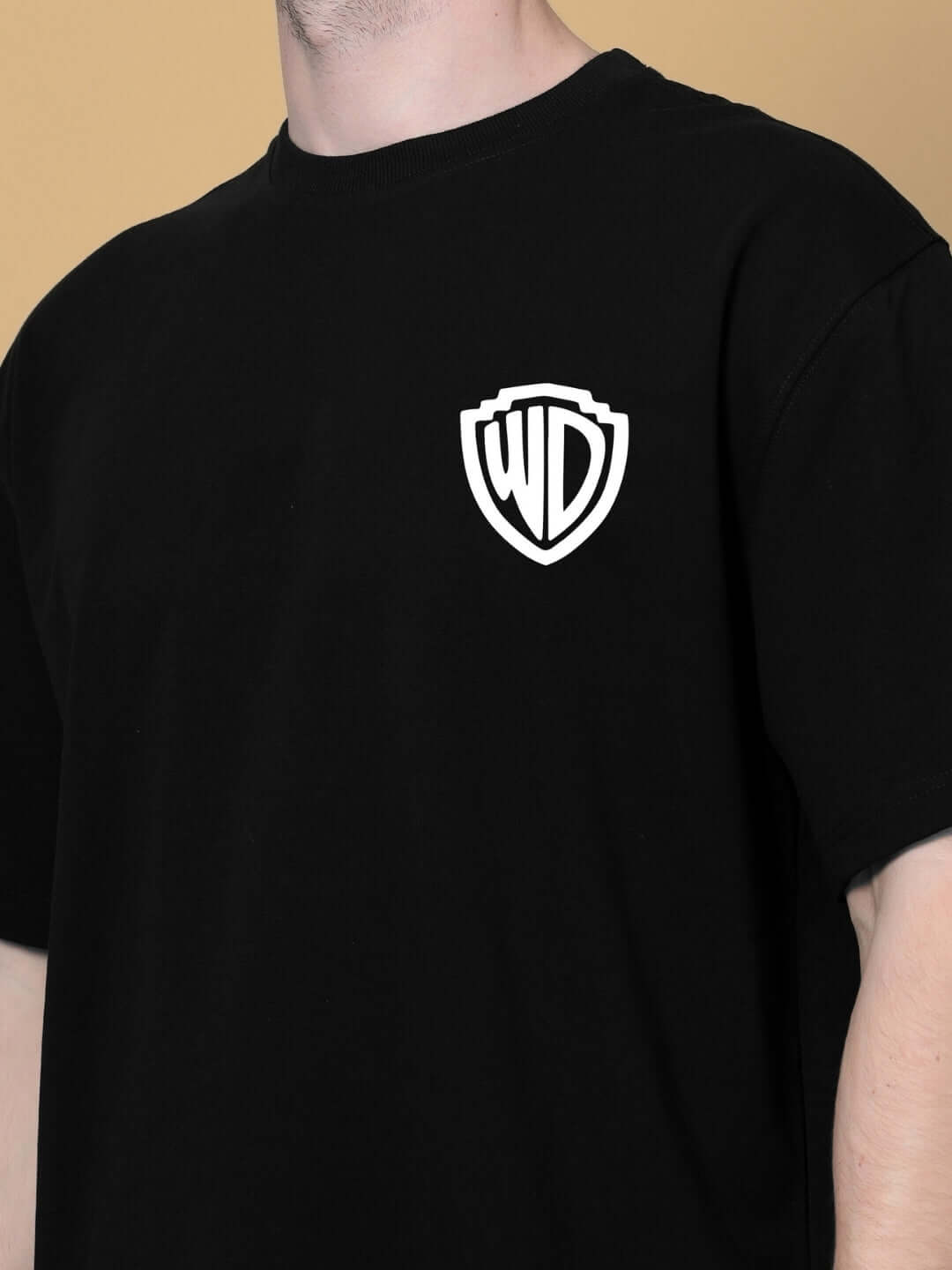Close-up of person wearing POLICIA OVER-SIZED T-SHIRT BLACK with logo on chest.