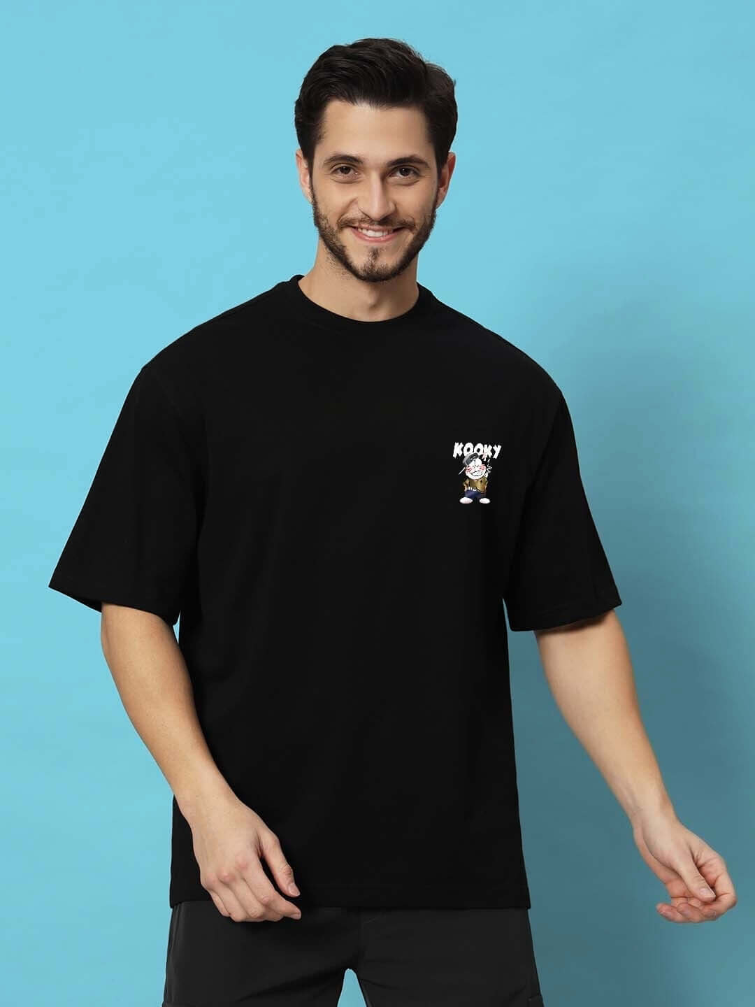 KOOKY OVER-SIZED T-SHIRT BLACK made from premium heavy gauge fabric, 97% cotton, worn by model against blue background.