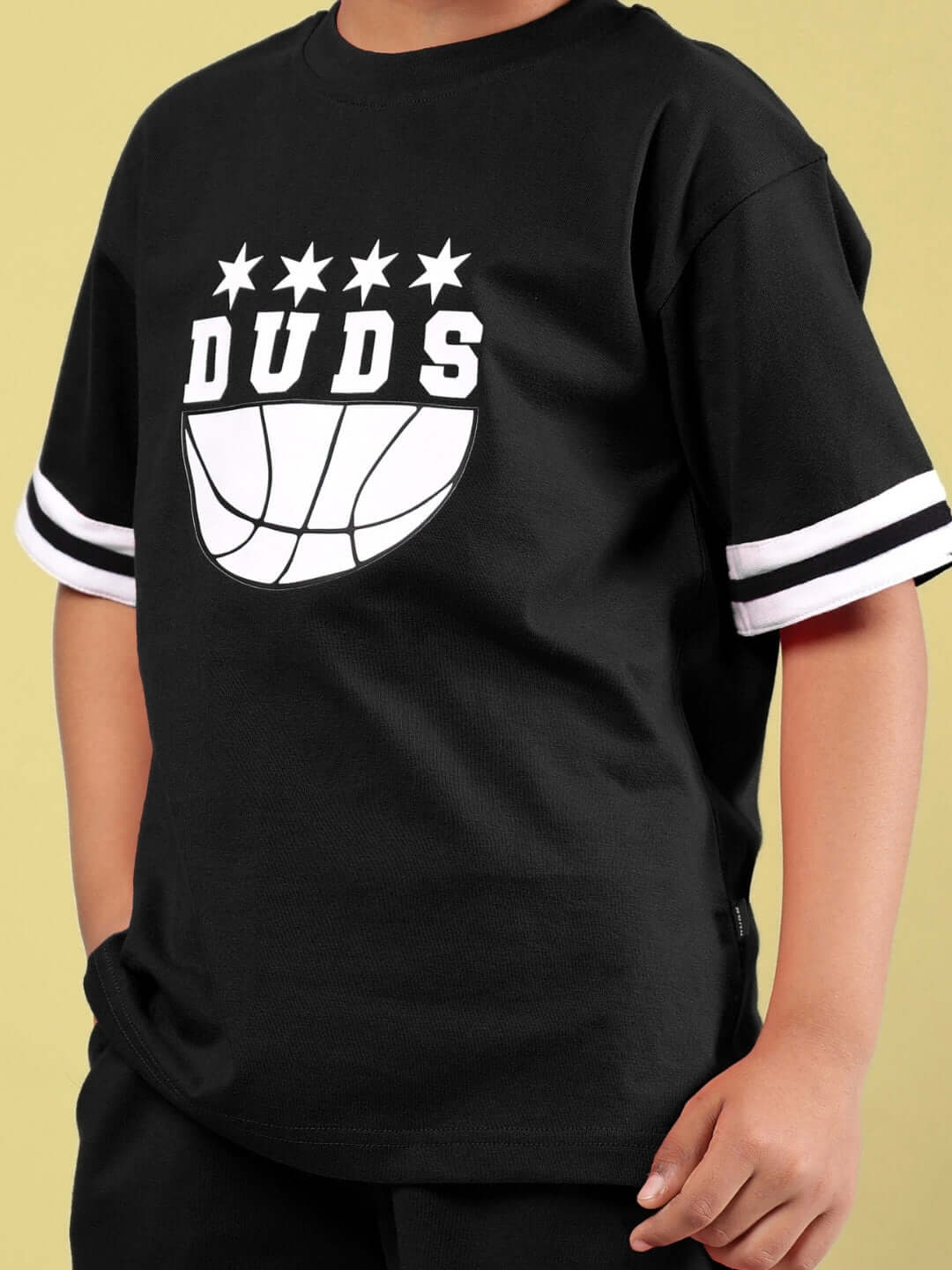 Child wearing black DIGGIN oversized t-shirt with DUDS logo and striped sleeves, made-to-order with custom fit options.