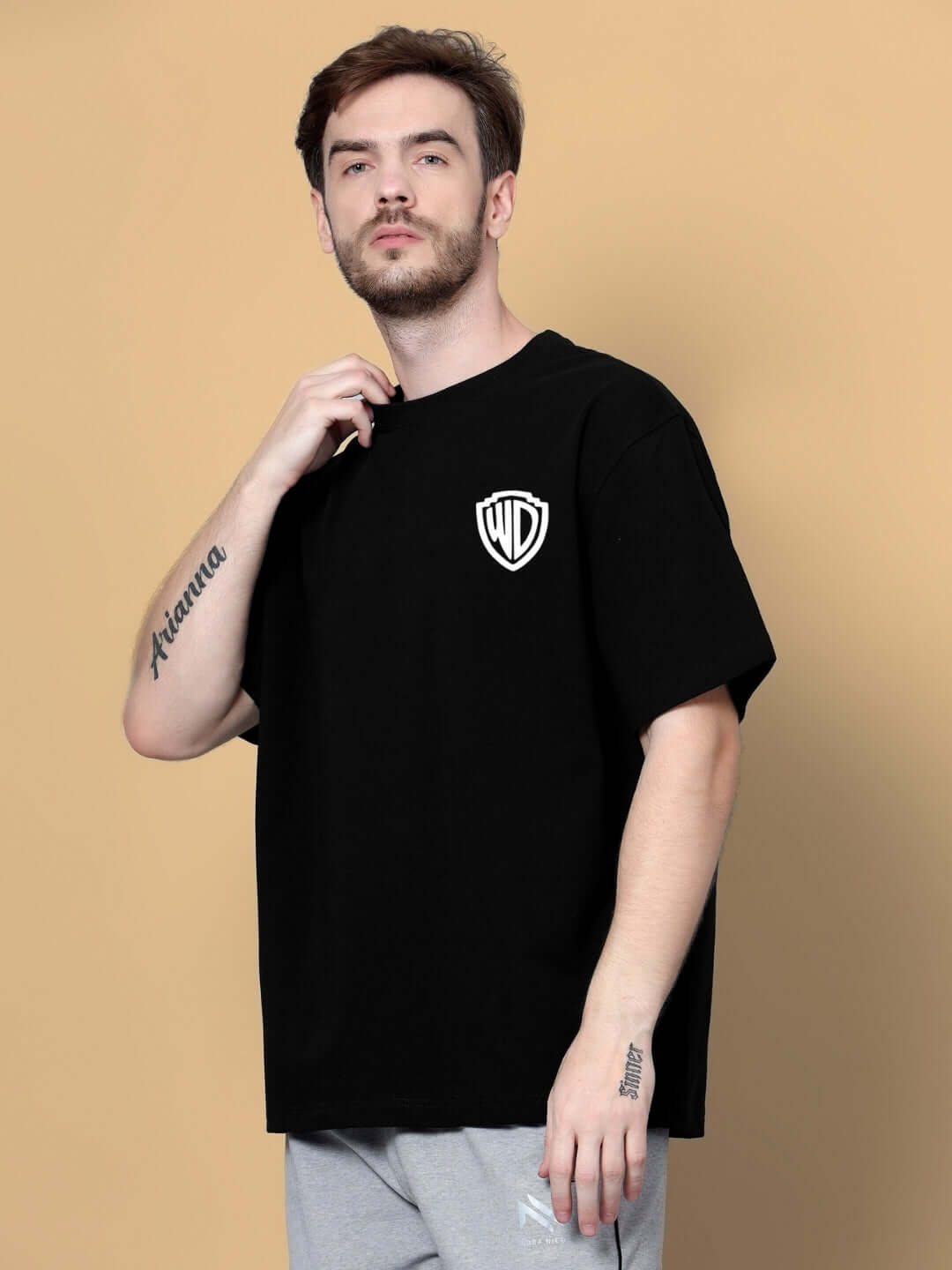 Model wearing POLICIA OVER-SIZED T-SHIRT BLACK with logo on chest, perfect for casual style.