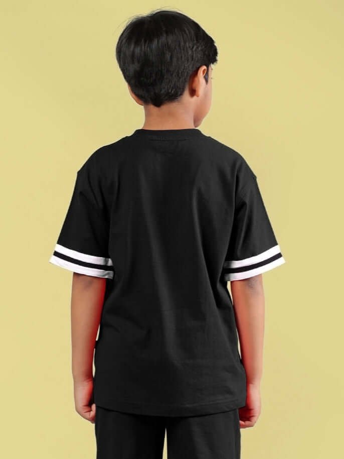 Child wearing Diggin oversized black t-shirt with white striped sleeves, back view. Comfortable and stylish unisex design for kids.