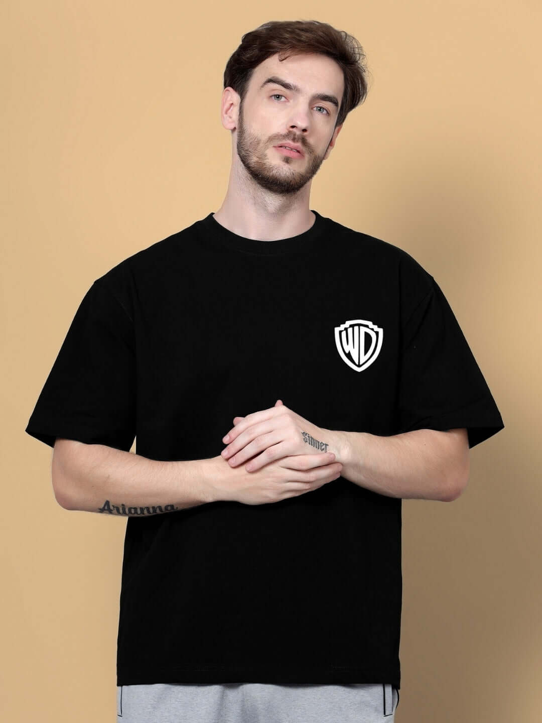 Man wearing POLICIA OVER-SIZED T-SHIRT BLACK with logo on front, customizable size available.