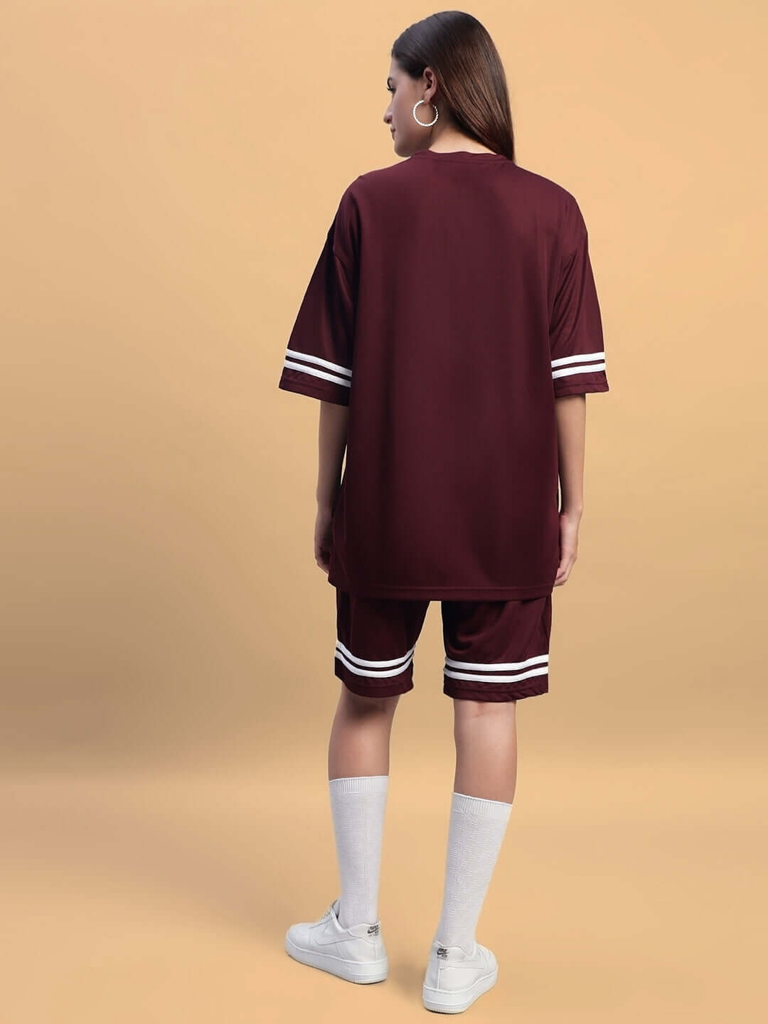 Model wearing women's groovy colorblock co-ord set in wine, sports polyester fabric, side view. Ideal for stylish casual wear.