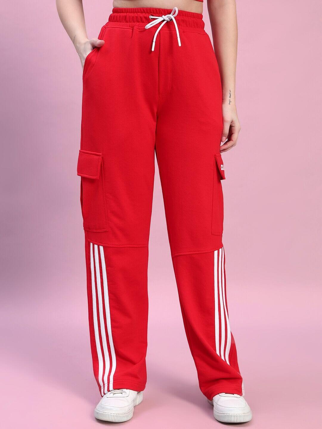 Stylish red women's Rosella co-ord set pants with white stripe detailing, made from premium cotton fabric. Model on pink background.