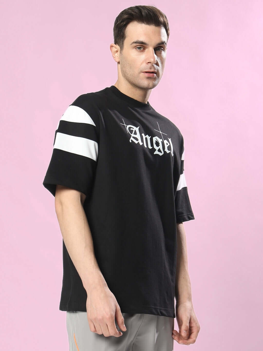 Model wearing DIVINE SPIRIT OVERSIZED T-SHIRT BLACK with white graphics, front view
