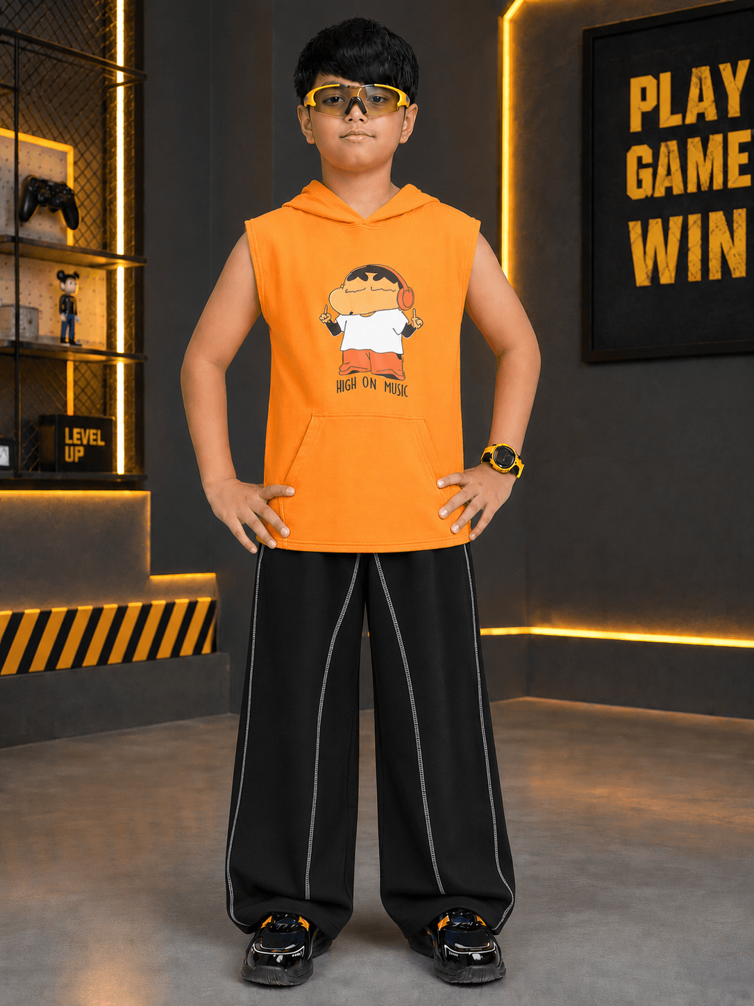A boy wearing the BEAT MODE HOODED CO-ORD FOR BOYS GIRLS ORANGE BLACK in a stylish gaming setup.