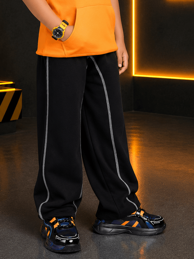 BEAT MODE JOGGER FOR BOYS GIRLS BLACK worn with an orange hoodie and stylish sneakers.