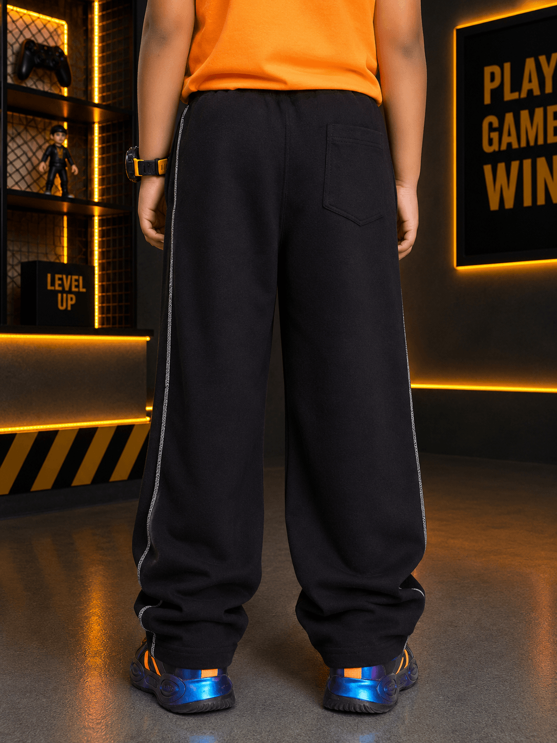 Child wearing BEAT MODE HOODED CO-ORD FOR BOYS GIRLS ORANGE BLACK, showcasing stylish black pants from behind.