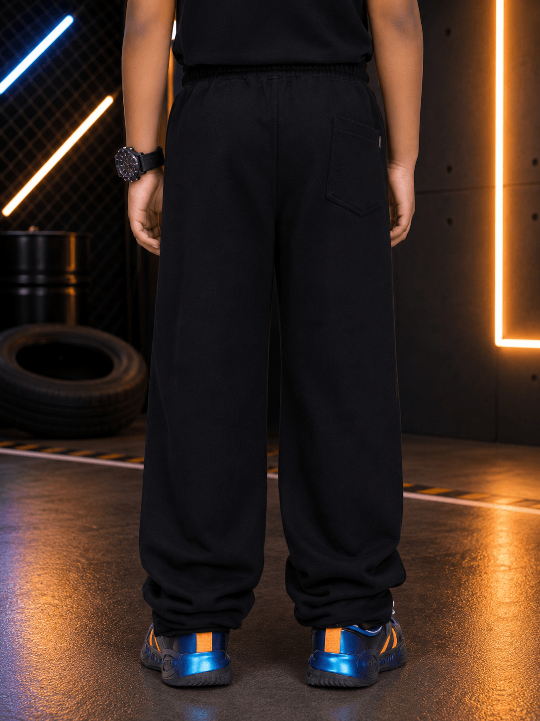 Back view of a child wearing PHANTOM SLEEVELESS HOODED CO-ORD FOR BOYS GIRLS BLACK with sporty black pants.