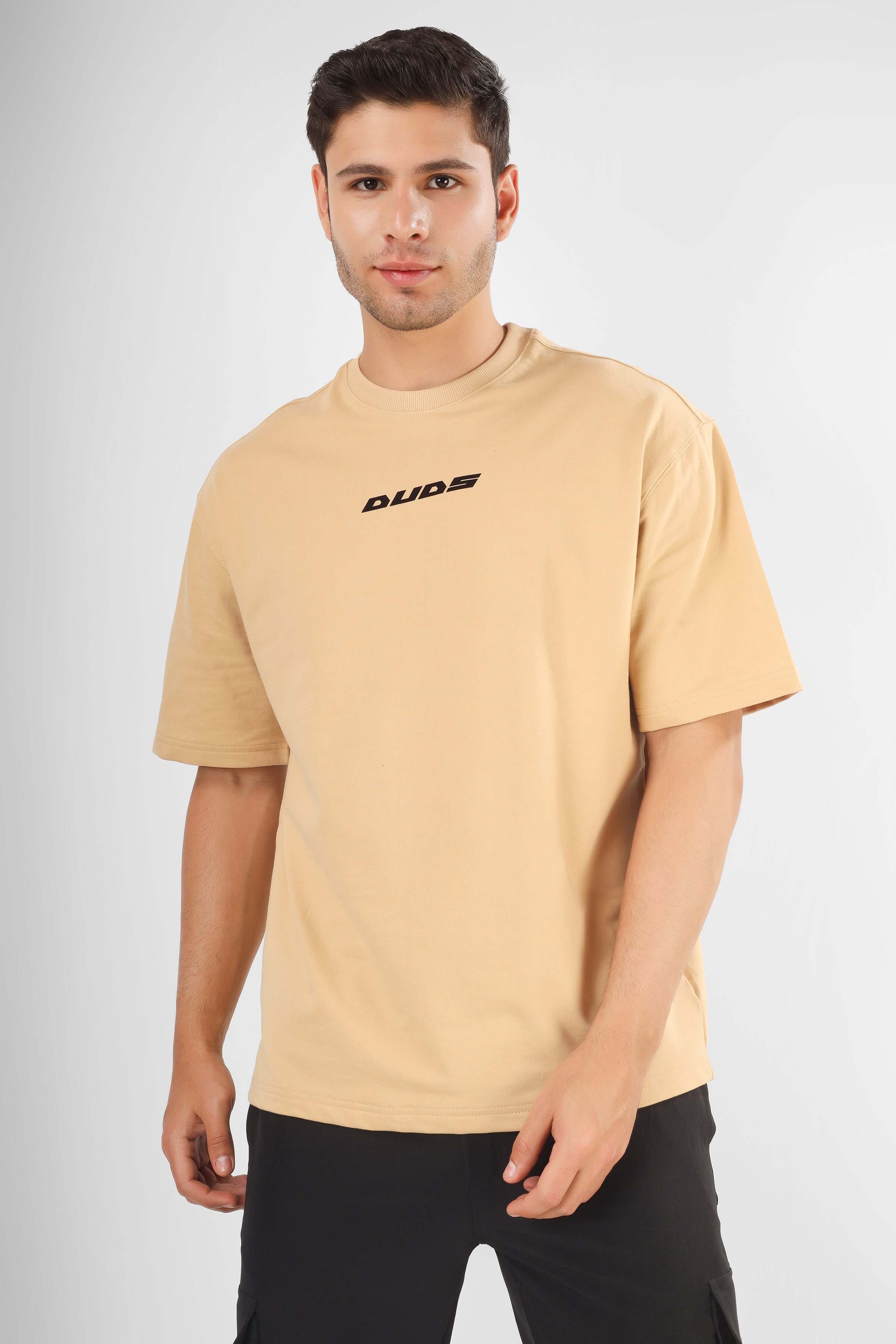 Man wearing POSITIVE MINDSET OVER-SIZED T-SHIRT NUDE, premium cotton French terry fabric with "Dude" logo.
