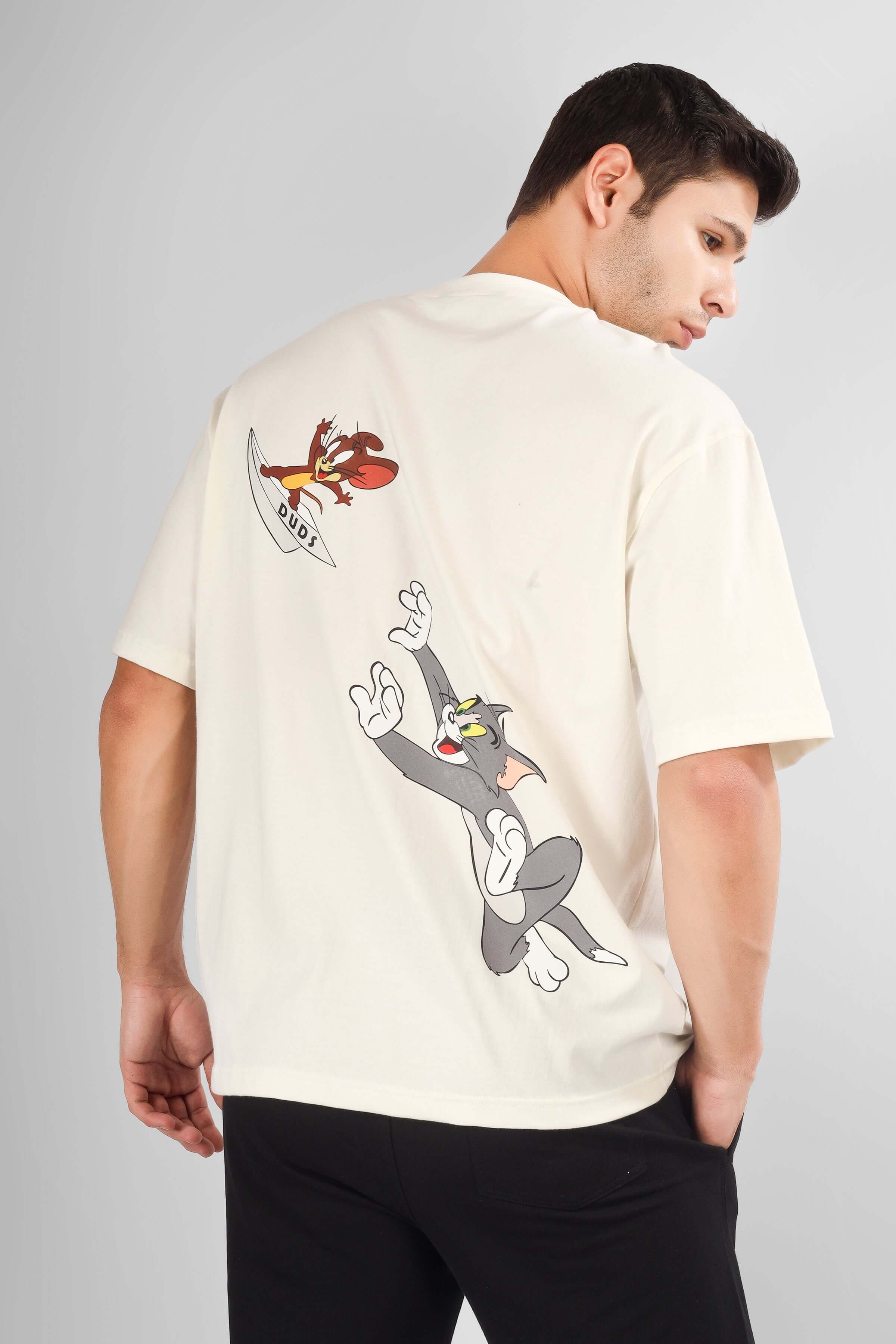 Man wearing TOM & JERRY OVER-SIZED T-SHIRT CREAM with cartoon print on back