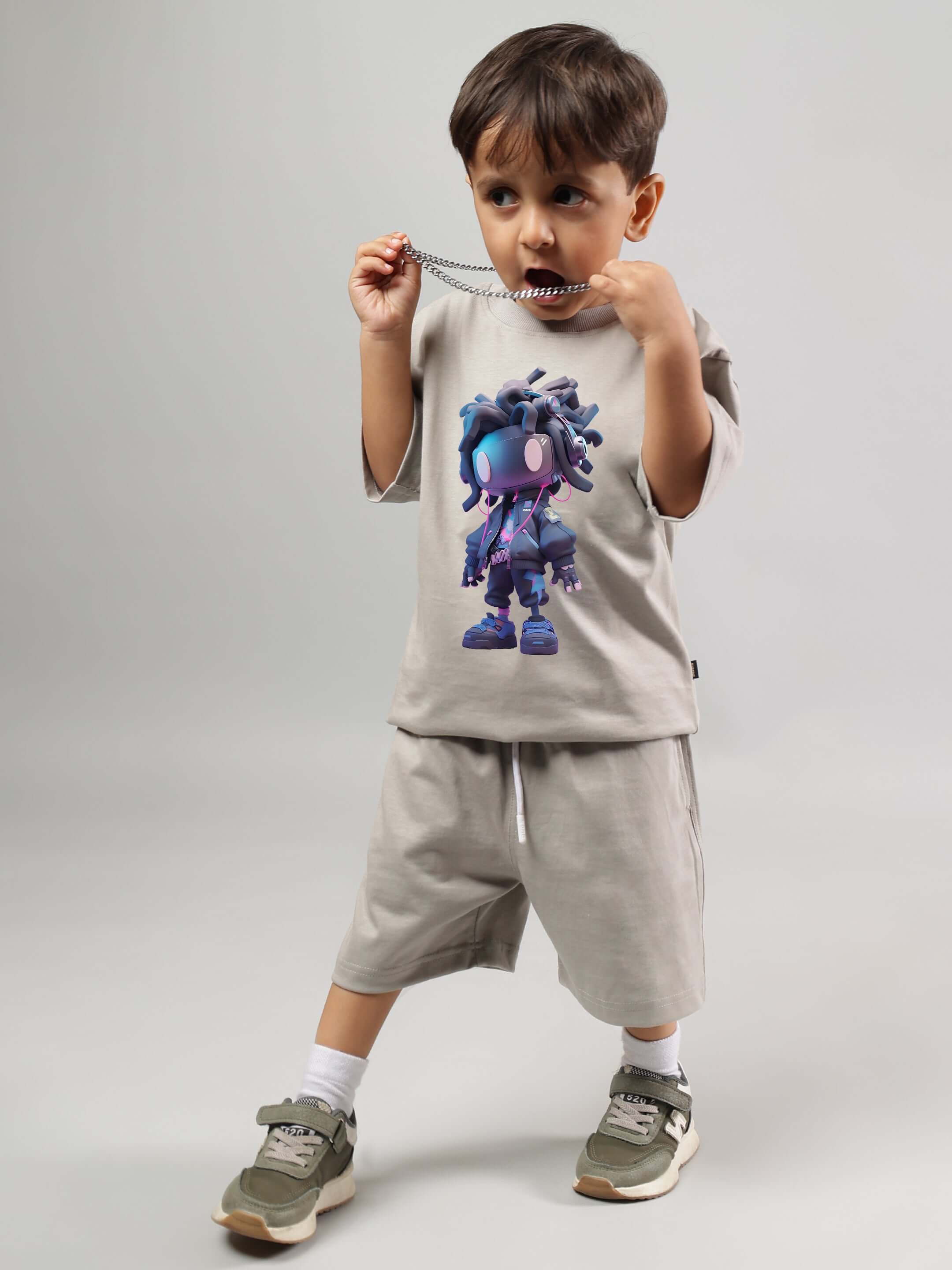 Young child wearing futuristic grey co-ord set for boys and girls, featuring a vibrant character print, by DUDS.