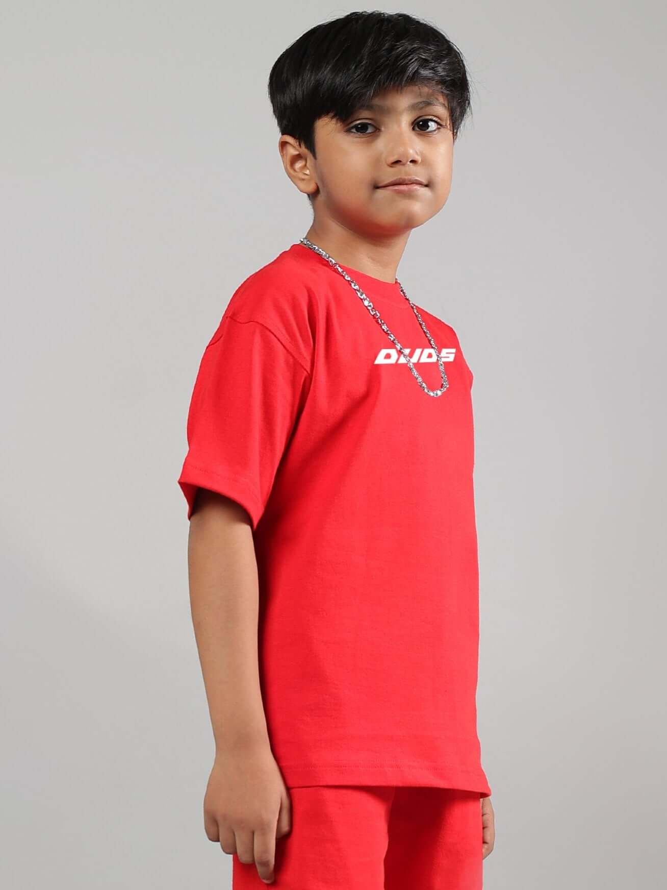 Boy wearing a red Victory T-shirt from DUDS, suitable for boys and girls, featuring a simple design, ideal for casual wear.