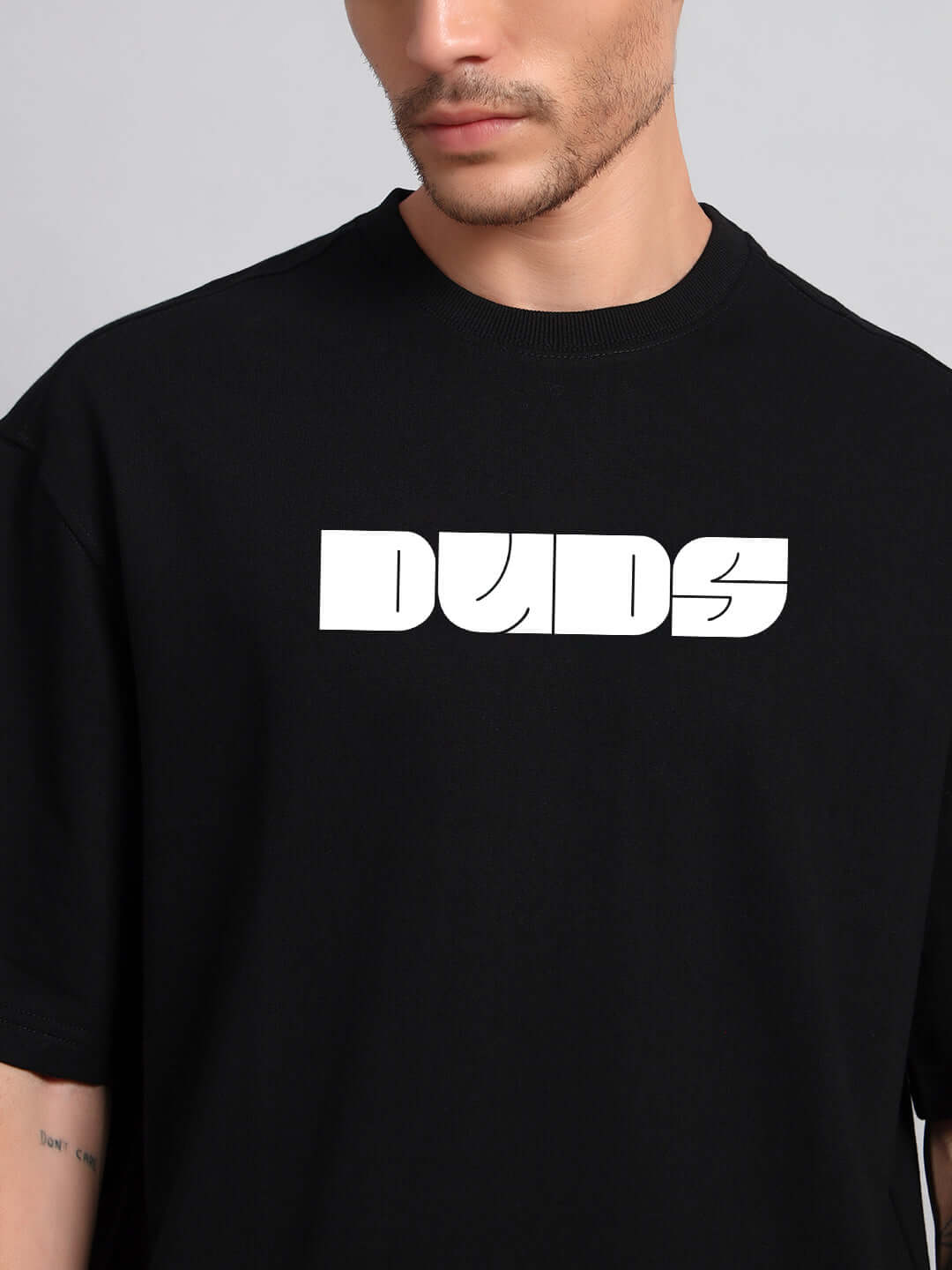 Model wearing black oversized GUNS AND ROSES t-shirt with graphic print, ideal for trendy summer style.
