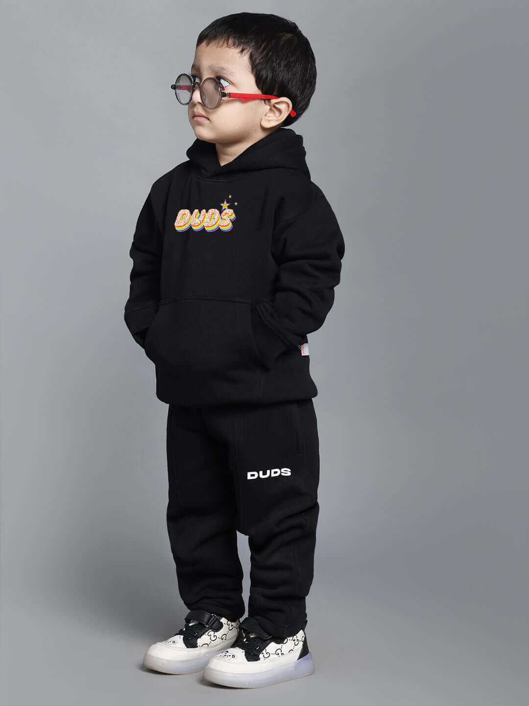 Child wearing "Born to Shine" black co-ord set, hoodie and pants, for boys and girls; stylish and comfortable casual wear.