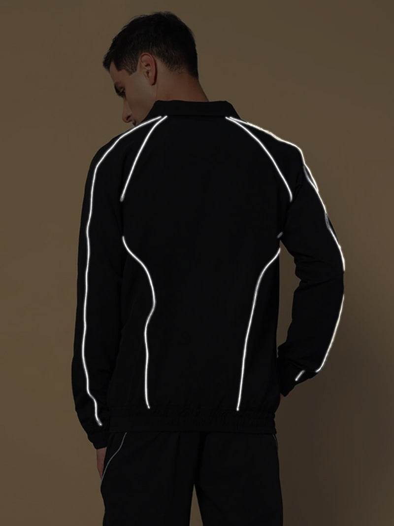 Model wearing LOCO REFLECTOR PARACHUTE SPORTS JACKET BLACK with reflective detailing, highlighting sporty style and utility.