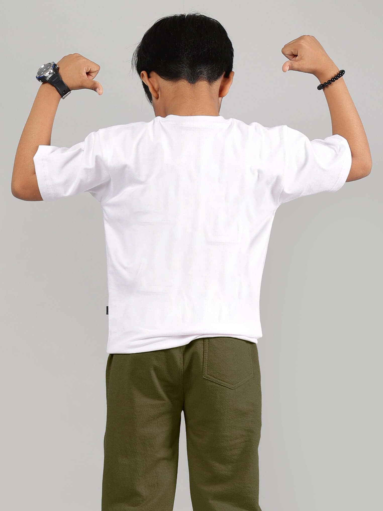 Child wearing white Winnie the Pooh t-shirt flexing muscles, showcasing back view.