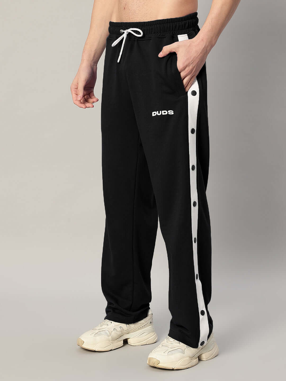 Unisex relaxed fit joggers, black with white stripe, elastic waistband, featuring brand logo, made from premium cotton blend fabric.