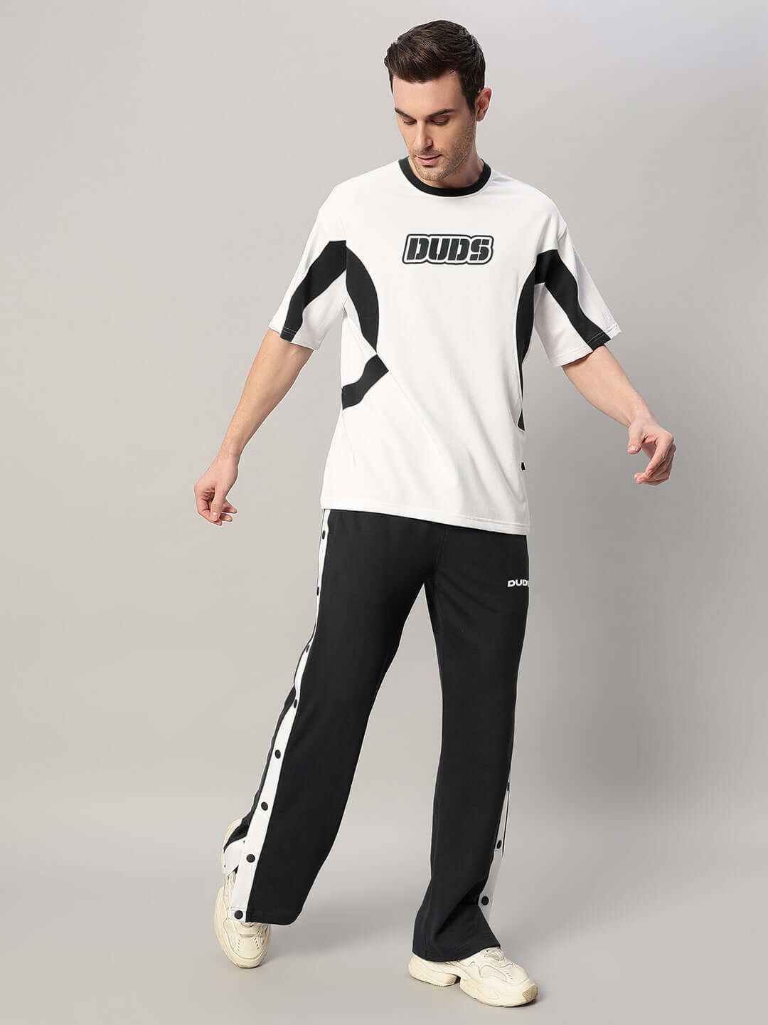 Model wearing EZEL Relaxed Fit Co-Ord Set, featuring a white-black unisex top and joggers with red & white panel accents.